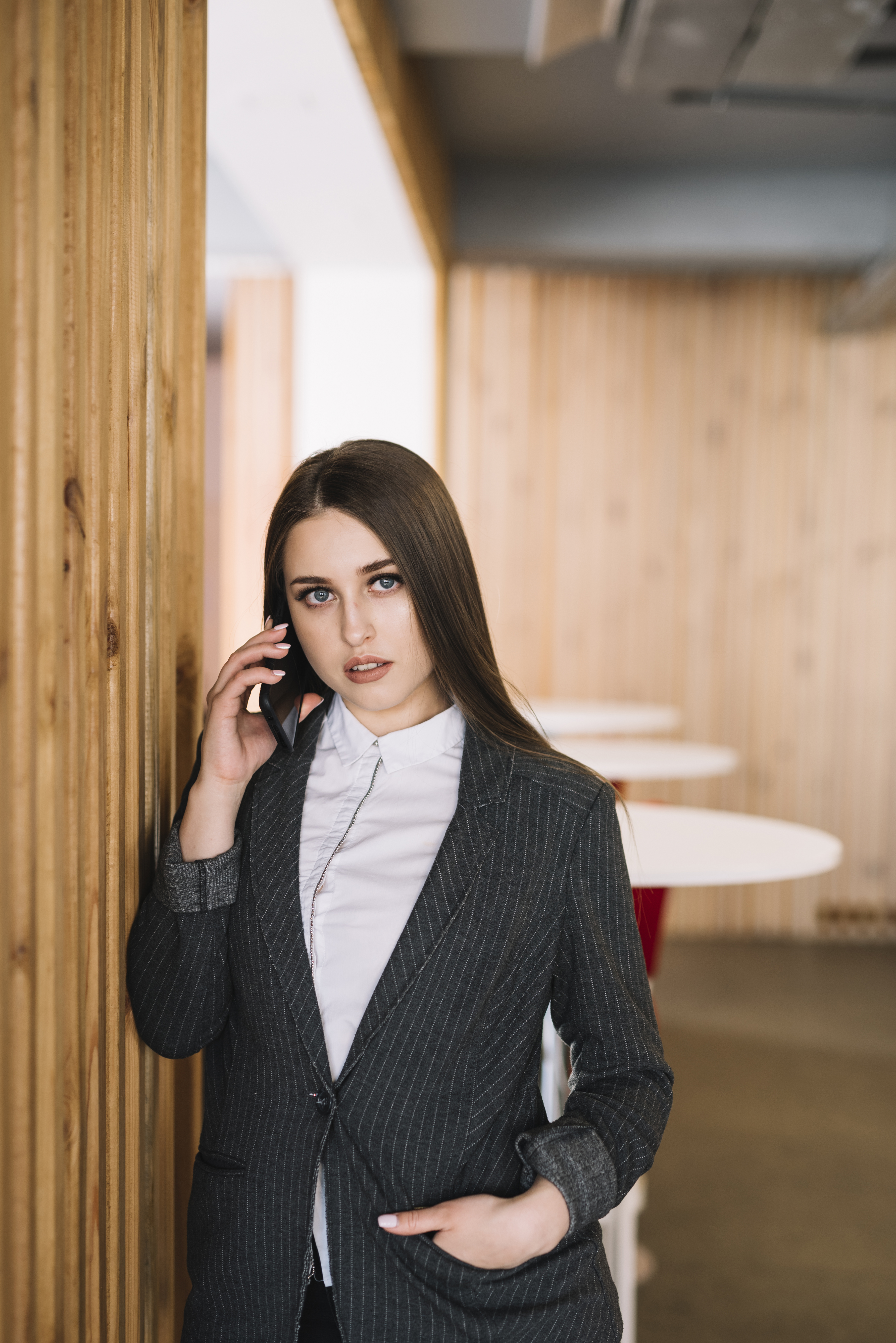 young-business-woman-talking-by-phone-wall.jpg